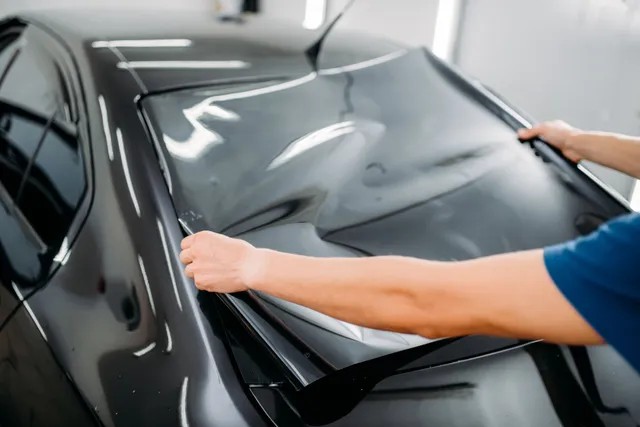 Tint film being measured against a windshield